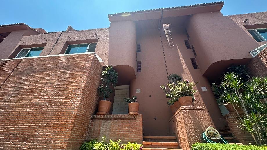 Fachada de ladrillo con jardineras y terrazas a tres niveles