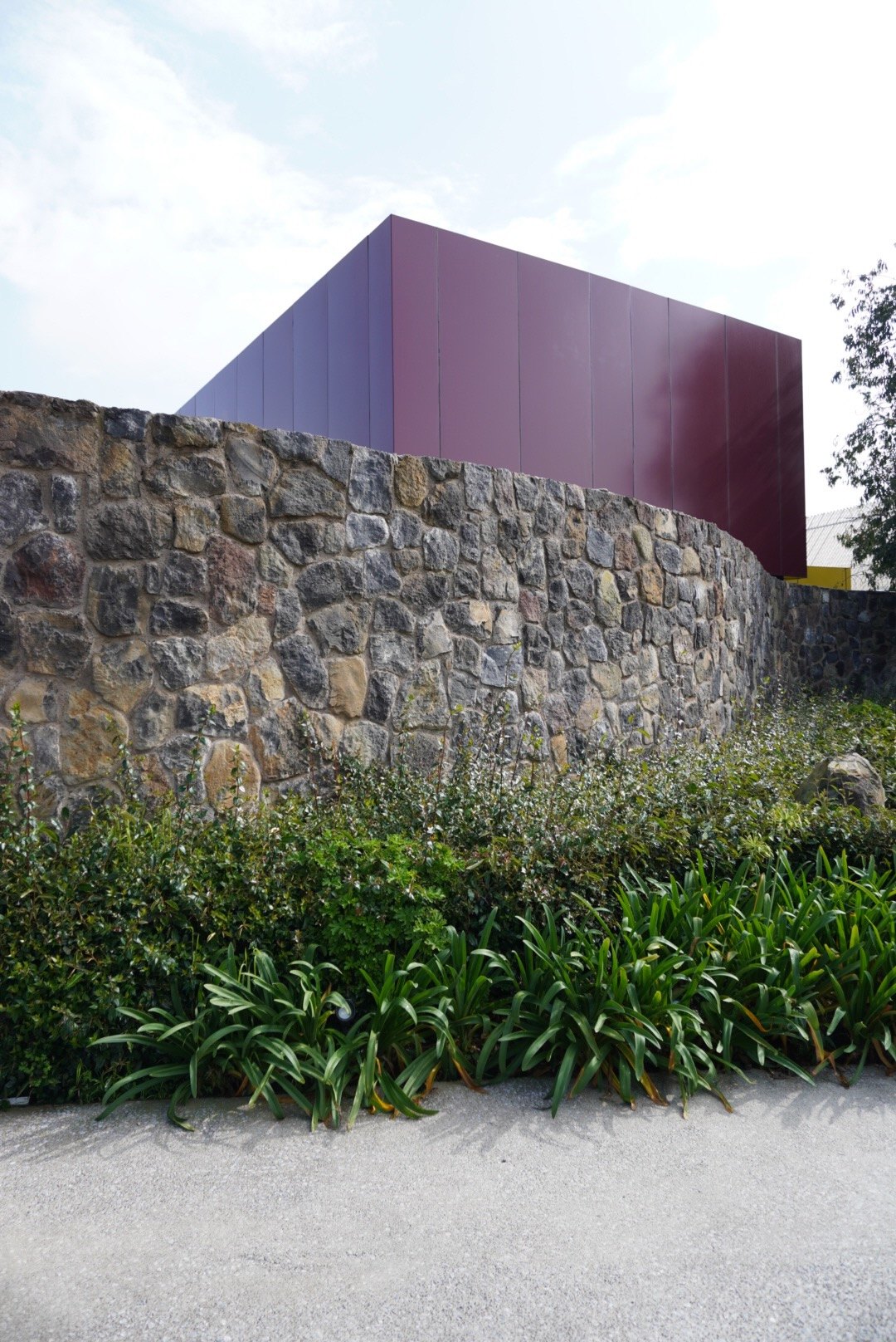 El volumen morado sobre el muro de piedra volcánica