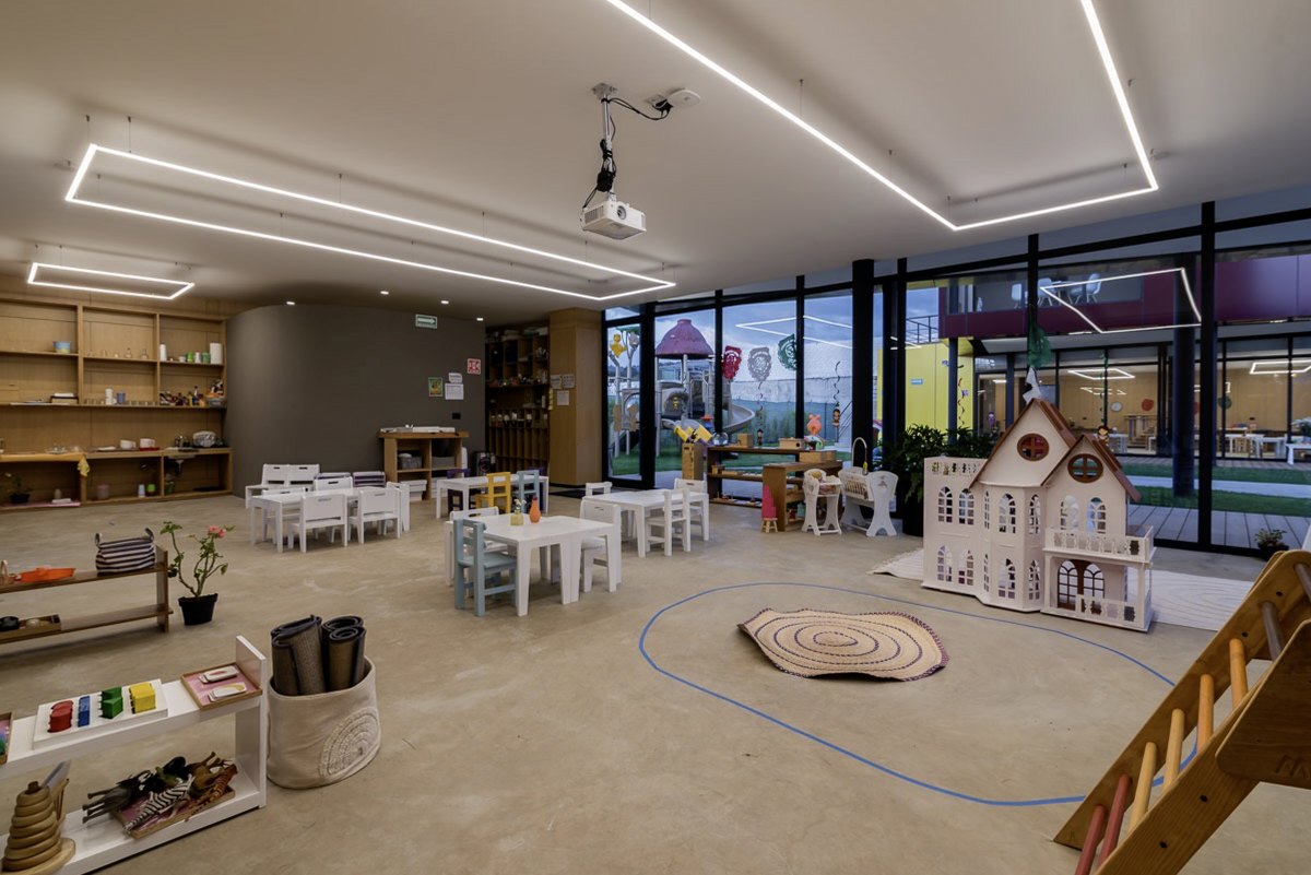 El aula con los juguetes y la alfombra, bajo la luz corrida