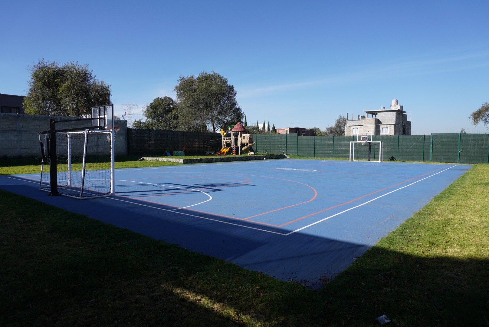 La cancha azul entre los árboles