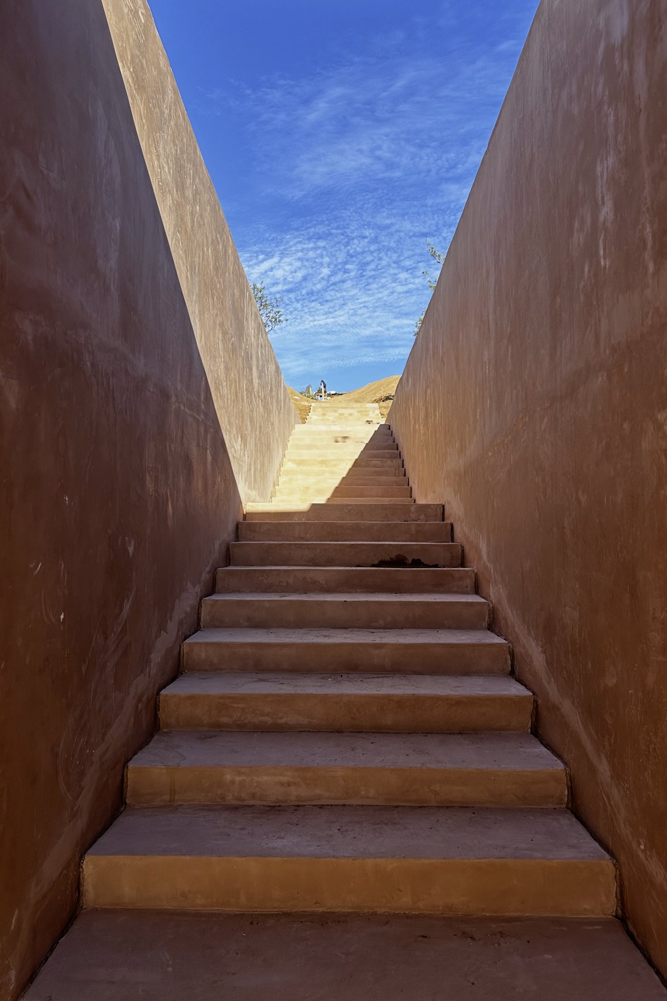 La escalera entre dos muros, abierta al cielo