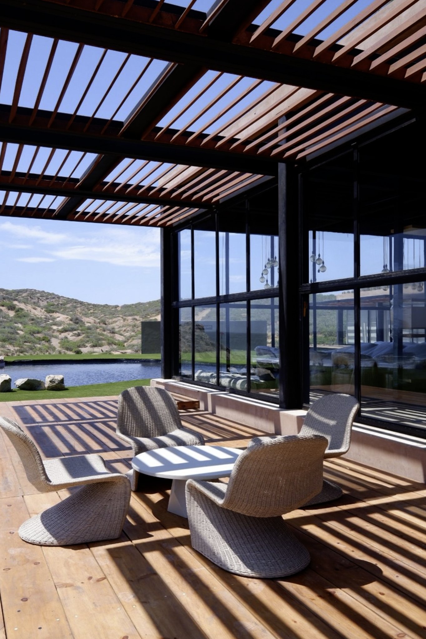 La terraza bajo la pérgola de listones, frente al valle
