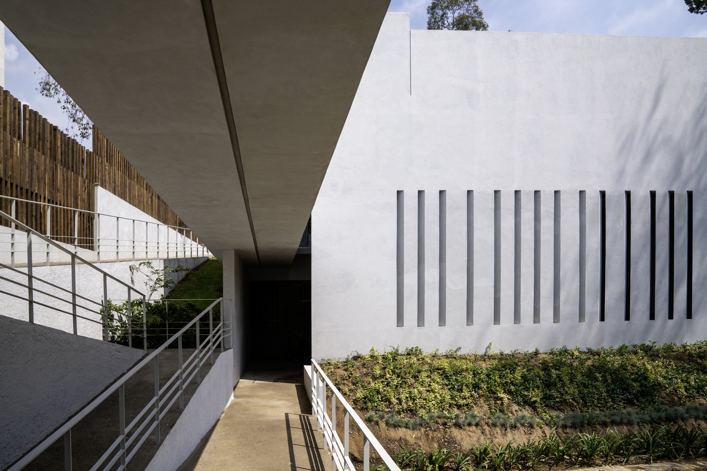 El puente de acceso junto a la celosía y las jardineras