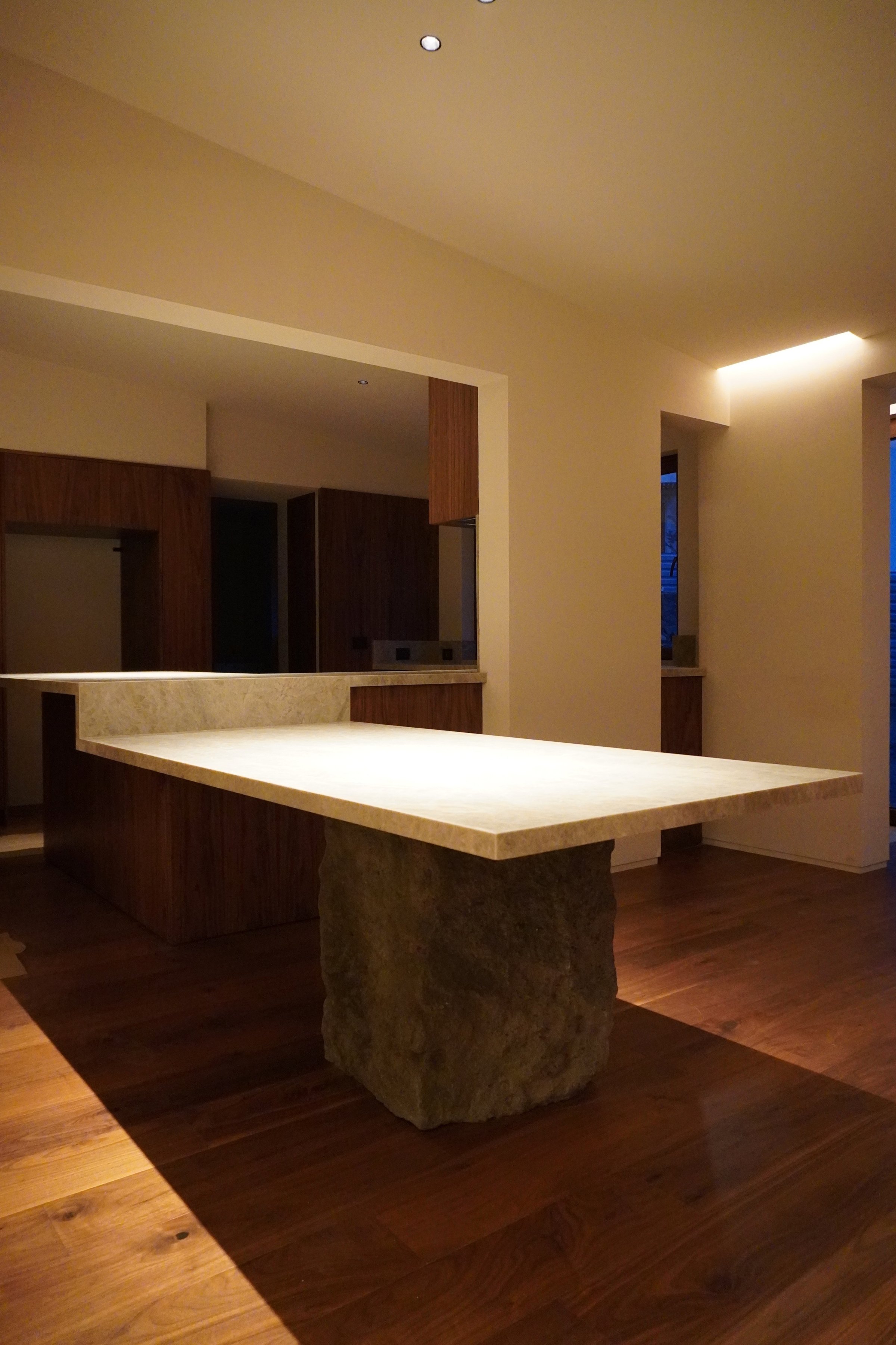 Cocina con la isla de piedra sobre el piso de madera
