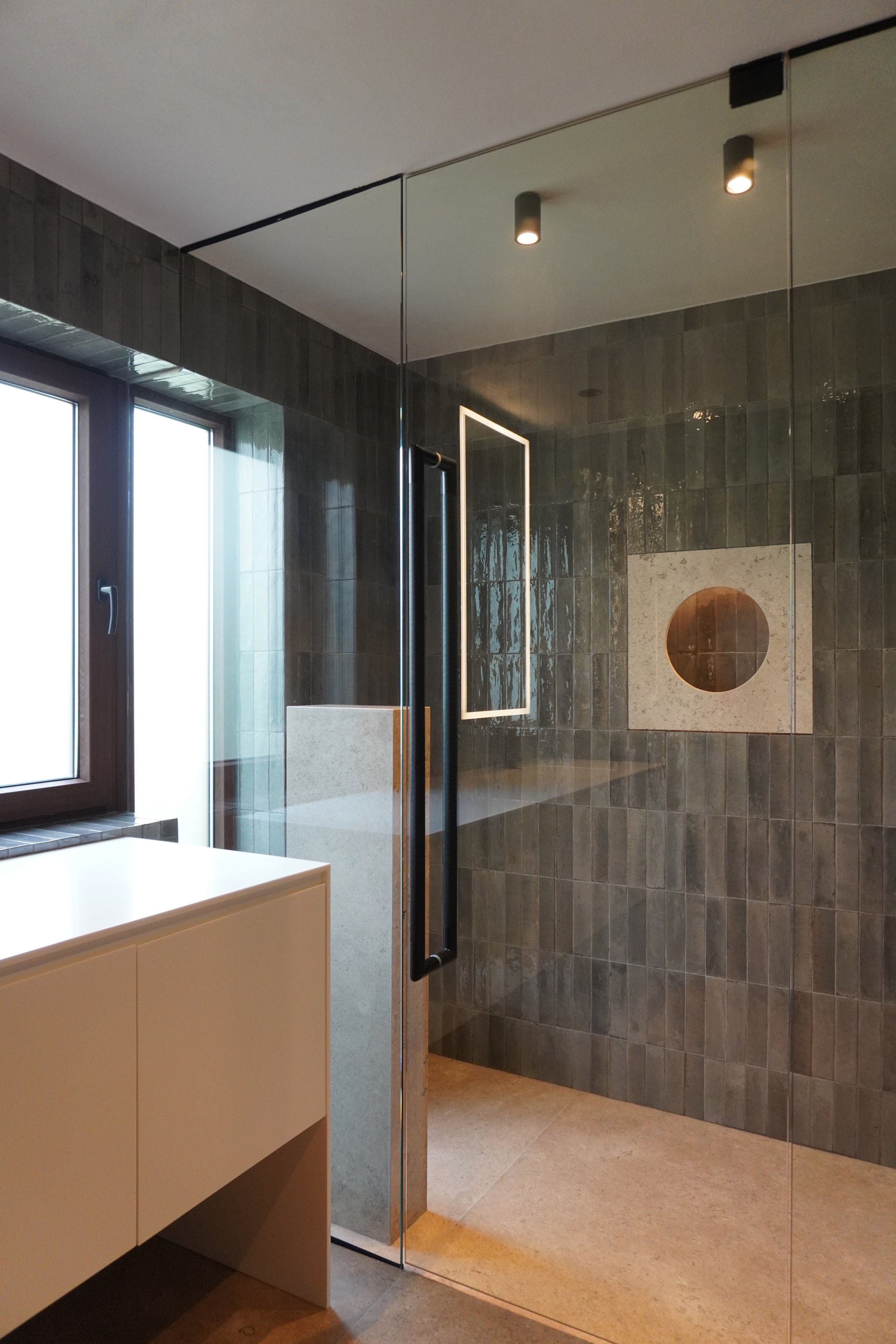 Baño con el lavabo volado y el muro de piedra
