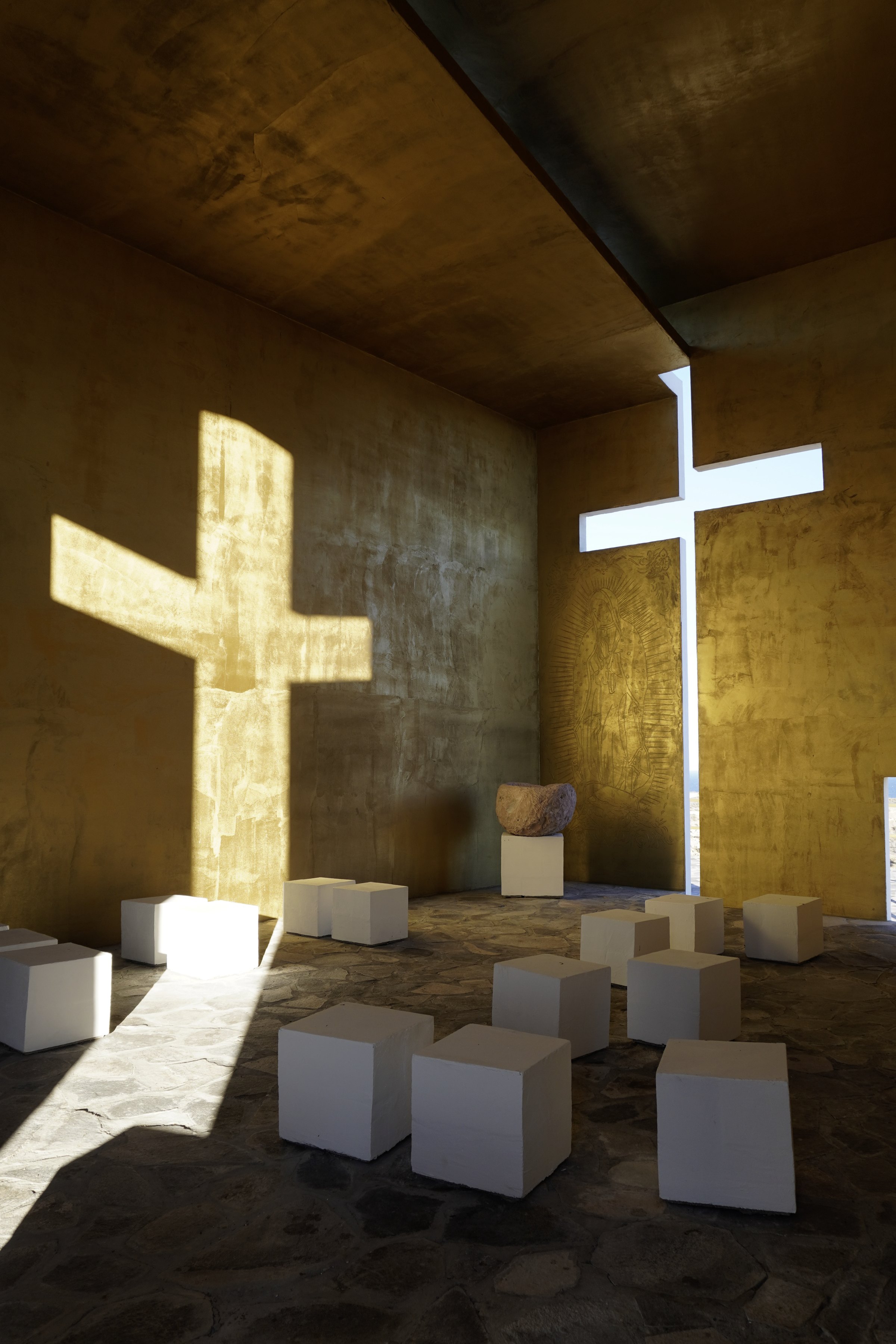 La luz de la cruz abriéndose sobre el muro de tierra