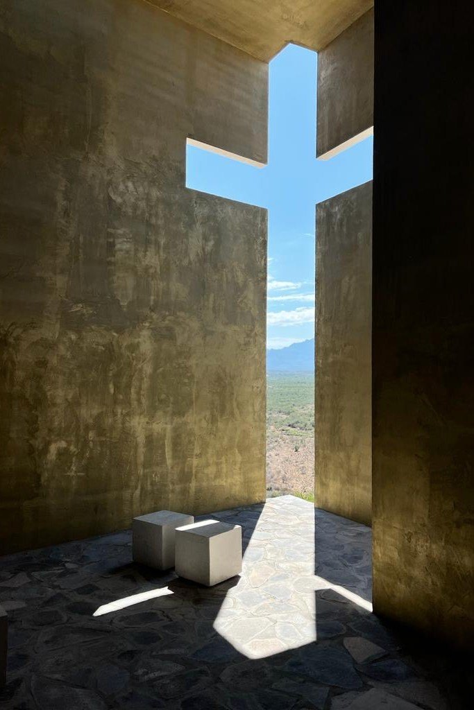 La cruz de luz vertical sobre el muro y el piso