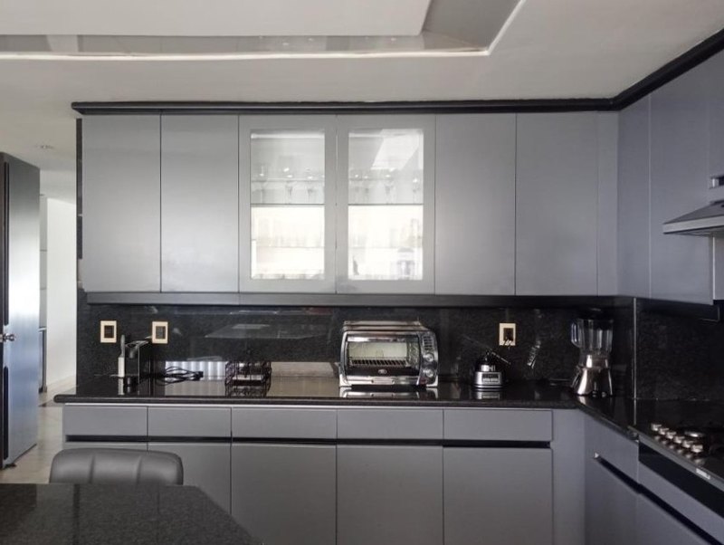 Cocina integral con muebles claros y encimera oscura